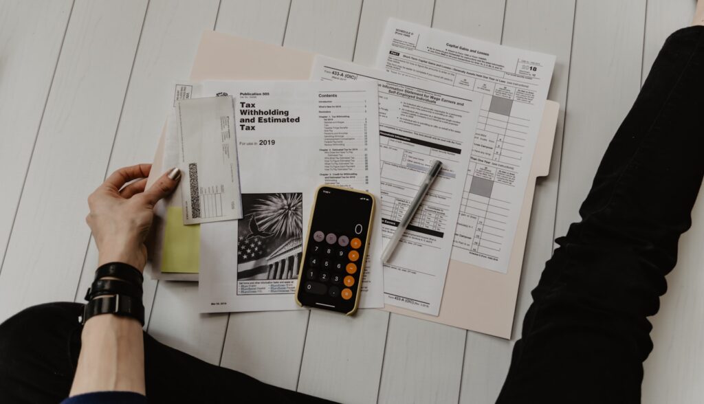 Calculator and a laptop displaying a project cost spreadsheet